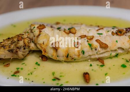 Bacalao con salsa al pil, piatto basco tradizionale con merluzzo salino in olio infuso all'aglio con guindilla peperoncino secco, in un ristorante a Pamplona, Spagna Foto Stock