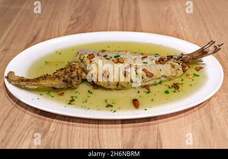 Bacalao con salsa al pil, piatto basco tradizionale con merluzzo salino in olio infuso all'aglio con guindilla peperoncino secco, in un ristorante a Pamplona, Spagna Foto Stock