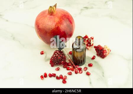 flacone cosmetico con pipetta contagocce riempito con olio di melograno per un'ulteriore idratazione in autonomia Foto Stock