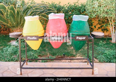 tre contenitori per il riciclaggio. raccolta di detriti: plastica, vetro e carta. Primo piano di foto di pentole colorate usate come contenitori di rifiuti. È molto importante Foto Stock