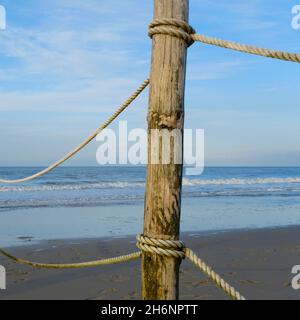 Palo in legno con corda sulla costa del Mare del Nord, bassa Sassonia, Germania Foto Stock