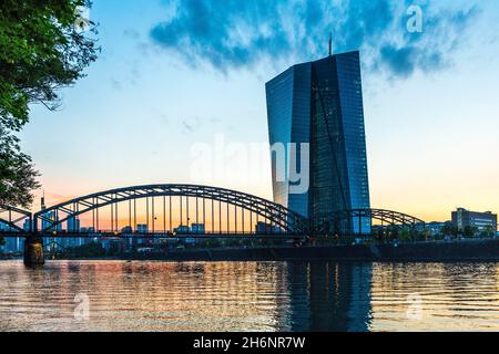 La Banca Centrale europea, BCE, all'ora blu con Deutschherrnbruecke e lo skyline di Francoforte da Deutschherrnufer, Francoforte sul meno, Assia, Germania Foto Stock