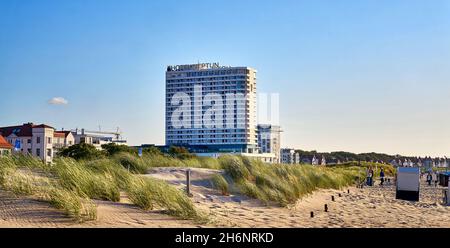 Scena sulla spiaggia del Mar Baltico a Warnemünde con il Neptun Hotel sullo sfondo. Foto Stock