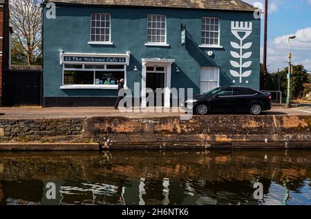 Dettagli e riflessioni sulla riva del fiume sul canale Exeter del 'The Welcome Cafe' con una pedone di passaggio. Foto Stock