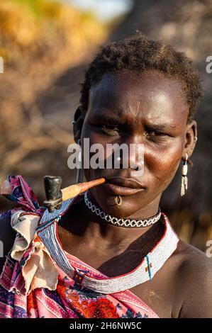 Donna della tribù Toposa che fuma una pipa, Equatoria orientale, Sudan meridionale Foto Stock