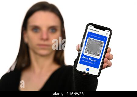 Symbol foto vaccinazioni privilegi, donna mostra app CovPass su smartphone con certificato di vaccinazione digitale europeo, incluso il codice QR, Corona Foto Stock