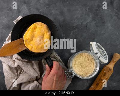 Piatto di pane di mais fatto in casa padella in mano maschile. Tortilla messicana fatta a mano per l'imballaggio. Ricetta tradizionale latina Foto Stock