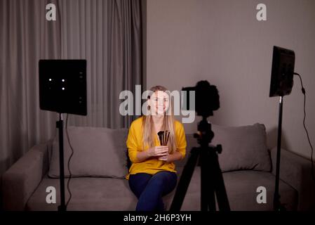 l'artista professionista del trucco registra un corso o un addestramento in linea per i suoi allievi nel paese usando la macchina fotografica e la luce video Foto Stock