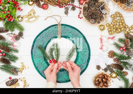 Passo dopo passo facendo una grande corona di Natale, passo 2 - prendere rami di conifere verde artificiale Foto Stock