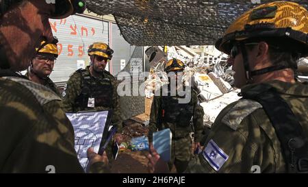 I soldati israeliani dell'unità di salvataggio del comando Home Front prendono parte a un trivello di ricerca e salvataggio in un grande sito di demolizione il 16 novembre 2021 a Tel Aviv, Israele. Il trapano Home Front simula l'operazione di ricerca e salvataggio preparando scenari che potrebbero distruggere edifici e intrappolare i cittadini a causa di un terremoto importante o massicce barrature di razzi. Foto Stock