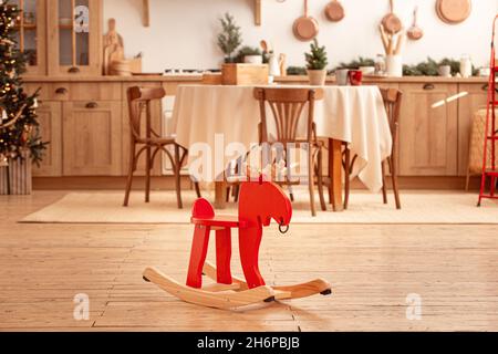 Cavallo rosso dondolante nella sala da cucina natalizia Foto Stock