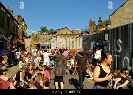 Londra, Gran Bretagna - 20 maggio 2018 : i giovani si divertono a bere e ad ascoltare i musicisti di strada a Hackney, Londra orientale in una giornata di sole Foto Stock