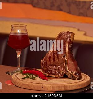 Entrecote manzo grigliato carne di manzo con rametto di rosmarino, pepe e sale. Bicchiere di birra nel ristorante o nel pub. Maestro chef che cucinano delizioso barbecue alla griglia Foto Stock