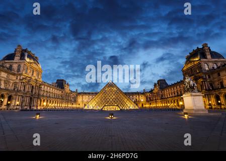 Museo del Louvre e la piramide illuminata di notte a Parigi Francia Foto Stock