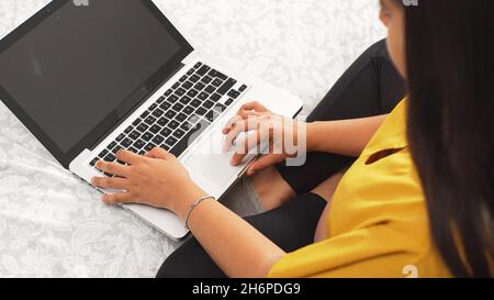 Primo piano di una giovane donna che lavora su un notebook. Foto Stock