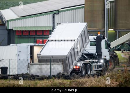 Vogelsang, Germania. 17 novembre 2021. Un autocarro porta un contenitore di trasporto chiuso nei locali dell'allevamento di suini colpiti dalla peste suina africana. È stata istituita l'attrezzatura tecnica per l'uccisione degli oltre 4,000 suini. Il primo focolaio di peste suina africana nel Meclemburgo-Pomerania occidentale si è verificato presso lo stabilimento. Come reazione al focolaio di ASF nel bestiame nel distretto di Rostock, tutti gli animali devono ora essere abbattuti e smaltiti. Credit: Jens Büttner/dpa-Zentralbild/dpa/Alamy Live News Foto Stock