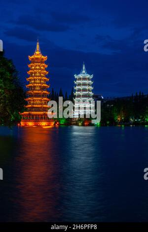 Vista notturna del Sole e Luna gemella Pagodas aka Oro e Argento Pagodas al Lago Shanhu (Fir Lake) a Guilin, Repubblica popolare Cinese. Foto Stock