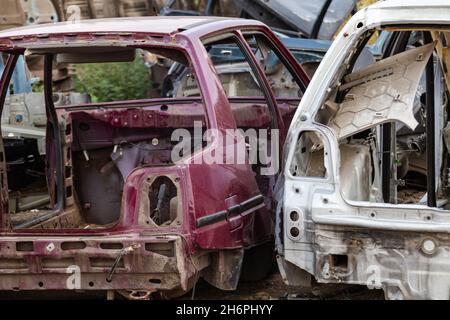 Vista ravvicinata di due carrozzerie smontate. Discarica auto, relitto in un deposito pronto per il riciclaggio Foto Stock
