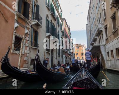 VENEZIA, ITALIA - 31 MAGGIO 2016: Canali stretti con traffico di gondole. Le gondole sono una tradizionale barca a remi veneziana a fondo piatto, ben adatta al co Foto Stock