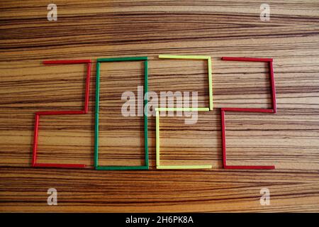Conte Holzstäbchen in rot, grün und gelb, auf einem Holztisch Liegend, die die Zahl 2022 darstellen. Foto Stock