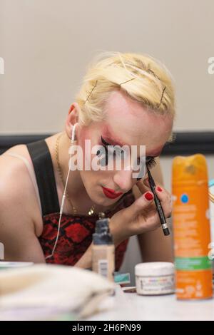 Regina di trascinamento maschile che applica il make-up prima di uno spettacolo. Foto Stock