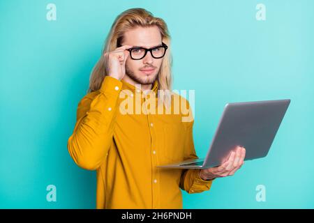 Foto di giovane uomo d'affari serio uso laptop coach seminario mano touch occhiali isolati su sfondo di colore turchese Foto Stock