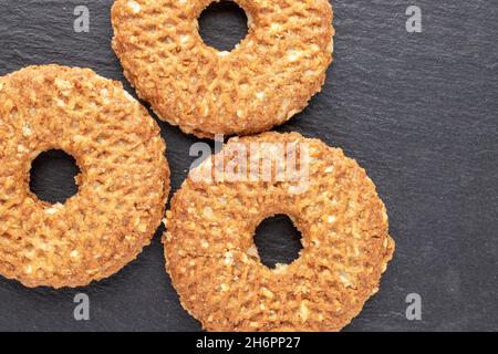 Tre biscotti fatti in casa con noci su una tavola di ardesia, primo piano, vista dall'alto. Foto Stock