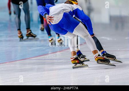 indietro uomini velocità skaters che corrono in pista di ghiaccio Foto Stock