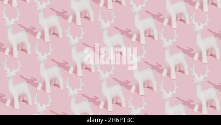 Motivo invernale rosa pastello creativo realizzato con ornamenti bianchi di renna su sfondo rosa. Composizione natalizia alla moda. Foto Stock