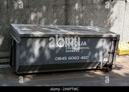 Londra, Inghilterra - Agosto 2021: Grande contenitore per rifiuti industriali su una rampa di accesso ad un edificio a Londra. Il bidone è di proprietà di Veolia Environmental Foto Stock