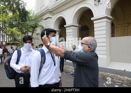 Kolkata Bengala Occidentale, India. 16 novembre 2021. Un insegnante regola la maschera facciale di uno studente prima di consentirgli di entrare nella scuola di Lepre, Kolkata, India il 16 novembre 2021. Le scuole hanno riaperto dopo un gap di più di due anni a causa della pandemia di coronavirus (Foto di Dipa Chakraborty/Pacific Press/Sipa USA) Credit: Sipa USA/Alamy Live News Foto Stock