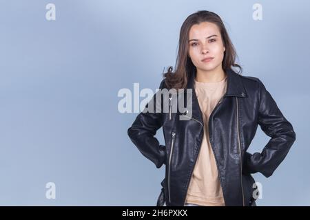 Bella giovane ragazza brunette in una giacca di pelle scura yawning. Foto Stock