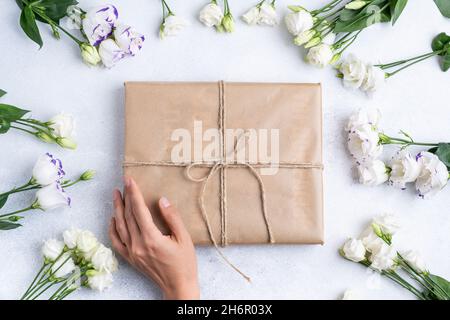 La composizione di fiori e borse. Un regalo e fiori su sfondo rosa. Giornata delle donne, una vacanza. Lettino solare piatto, vista dall'alto, spazio copia. Foto Stock