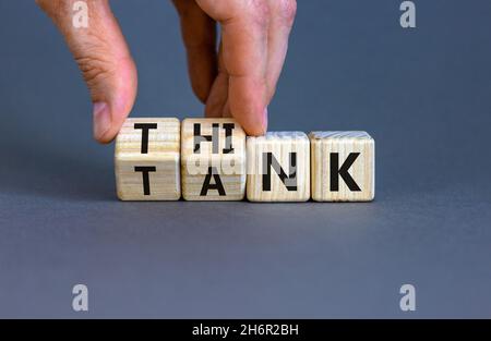 Think Tank. L'uomo d'affari trasforma i cubi di legno e cambia la parola 'serbatoio' in 'pensare' o viceversa. Bella tabella grigia, sfondo grigio, copia sp Foto Stock