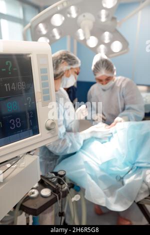 Monitoraggio del cuore del paziente in unità di terapia intensiva in sala operatoria. Foto Stock