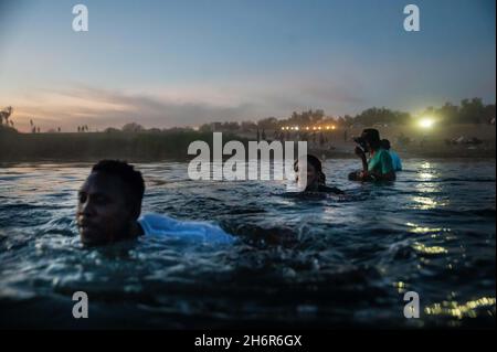 Acuna, Coahuila De Zaragoza, Messico. 22 settembre 2021. I migranti nuotano sul Rio Grande dal Messico agli Stati Uniti mentre tramonta il sole. Migliaia di migranti haitiani sono apparsi al confine tra Stati Uniti e Messico cercando di attraversare il Rio Grande e trovare rifugio negli Stati Uniti. (Credit Image: © Raquel Natalicchio/ZUMA Press Wire) Foto Stock