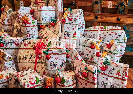 I regali avvolti davanti ad un vecchio tavolo di legno che fanno parte di un calendario dell'avvento. Foto Stock