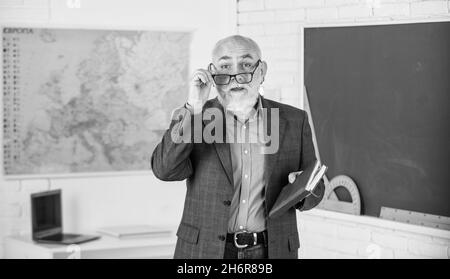 Insegnante di vecchia generazione di scuola. Insegnante di uomo intelligente senior alla lavagna. Docente esperto. Insegnante maturo godere di insegnamento. Condivisione delle conoscenze Foto Stock