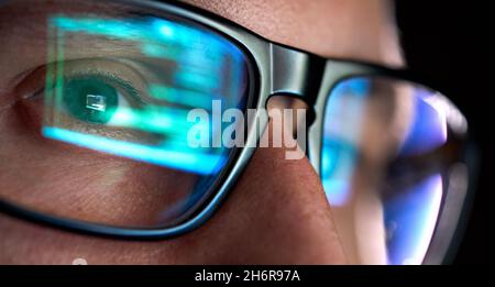 Programmatore sviluppatore che guarda al computer, il codice di programmazione riflette negli occhiali. Foto Stock