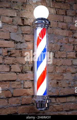 Barber's Pole su un muro di mattoni sfondo Foto Stock
