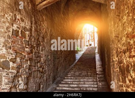 Perugia, Umbria, Italia. Agosto 2021. Un incantevole vicolo con volte ad arco ci porta su una scala nel cuore del centro storico. Foto Stock