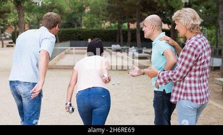 Allegri maschi e femmine che giocano a petanque Foto Stock