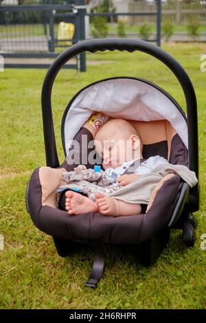 vista completa di un adorabile bambino che dorme in un pam all'aperto Foto Stock