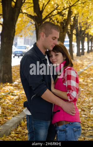 Bella coppia divertirsi insieme nella natura. La coppia sta godendo la caduta e l'un l'altro. Ragazzo e ragazza innamorati camminano nel parco. Concetto di amore. Foto Stock