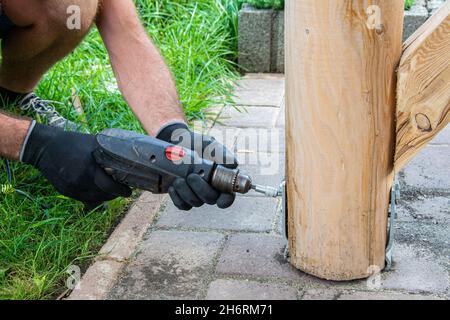 Gli operatori che indossano i guanti devono utilizzare un cacciavite elettrico per serrare la vite. Foto Stock