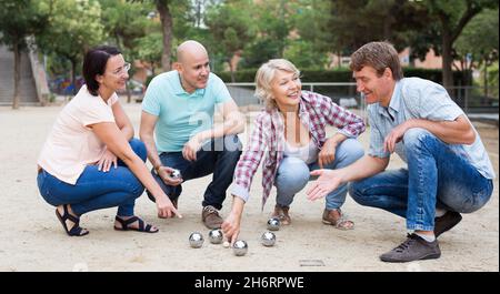 Allegri maschi e femmine che giocano a petanque Foto Stock