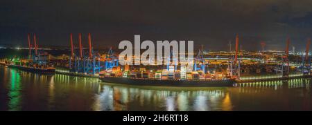 Terminal container, carico e scarico di vari container e la stazione di trasporto di notte. Porto marittimo sul fiume Elba ad Amburgo Foto Stock