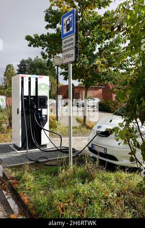 Elektroauto wird an einer Ladesäule auf einem öffentlichen Parkplatz geladen, Niedersachsen, Deutschland, Uelzen Foto Stock