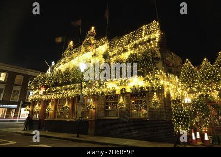 Londra, Regno Unito. 17 novembre 2021. La spettacolare esposizione annuale di Natale al Churchill Arms di Kensington ritorna con 80 alberi e migliaia di luci che coprono l'esterno dell'edificio. La tradizione festiva iniziò nel 1987, con 12 alberi di abete e le esposizioni crebbero più grandi e più elaborate ogni anno che passò. Credit: Undicesima ora Fotografia/Alamy Live News Foto Stock