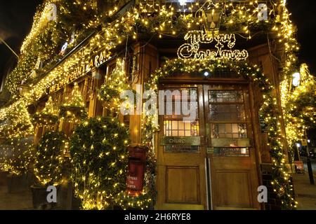 Londra, Regno Unito. 17 novembre 2021. La spettacolare esposizione annuale di Natale al Churchill Arms di Kensington ritorna con 80 alberi e migliaia di luci che coprono l'esterno dell'edificio. La tradizione festiva iniziò nel 1987, con 12 alberi di abete e le esposizioni crebbero più grandi e più elaborate ogni anno che passò. Credit: Undicesima ora Fotografia/Alamy Live News Foto Stock